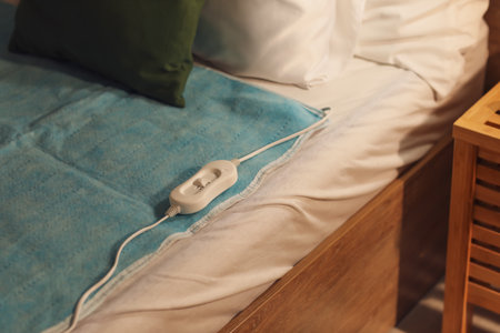 Electric heating pad with controller on bed at night, closeupの写真素材