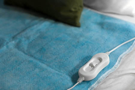 Electric heating pad with controller on bed at night, closeupの写真素材