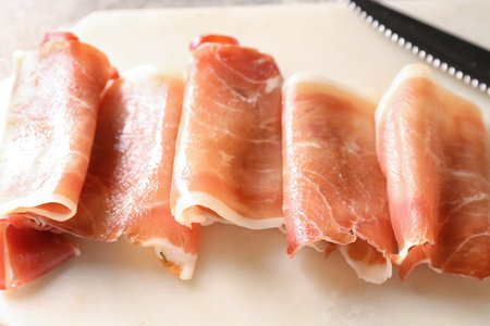 Board with rolled slices of delicious ham, closeupの写真素材