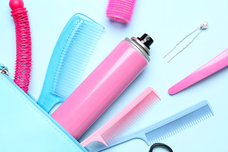 Bag with hair spray, combs and clips on blue background, closeupの写真素材