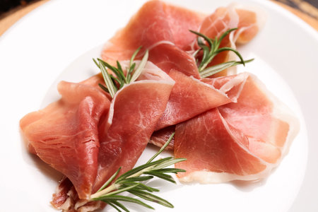 Plate with slices of tasty ham and rosemary, closeupの写真素材