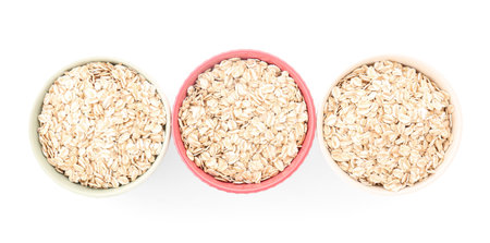 Bowls of raw oatmeal on white backgroundの写真素材