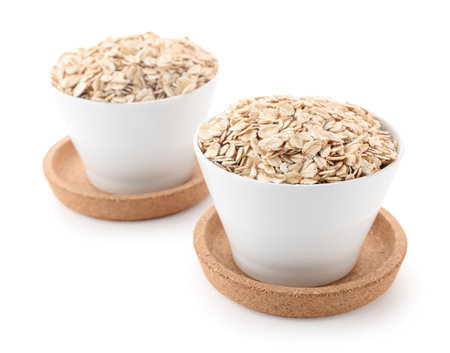 Bowls of raw oatmeal isolated on white backgroundの写真素材