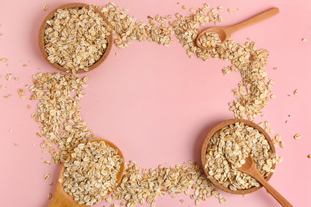 Frame made of raw oatmeal on pink background