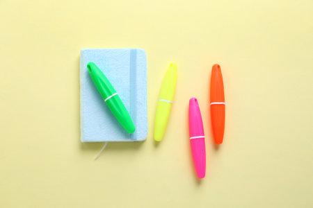Notebook and colorful markers on color backgroundの写真素材