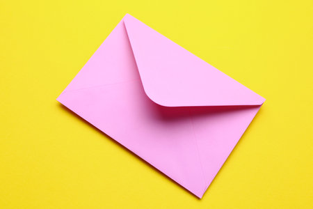 pink envelope on yellow backgroundの写真素材
