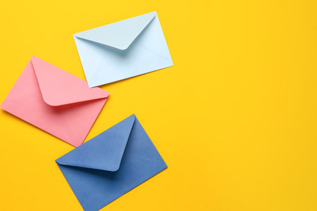 Colorful envelopes on yellow backgroundの写真素材