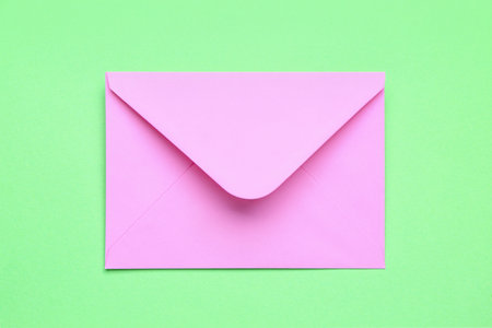 Pink paper envelope on green backgroundの写真素材