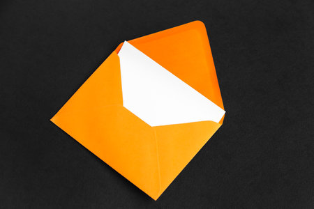 Orange paper envelope with card on dark backgroundの写真素材