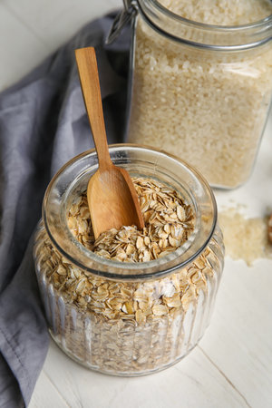 Glass jar with oatmeal on light wooden table, closeupの写真素材