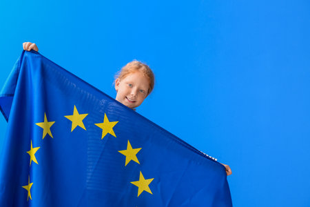 Little girl with flag of European Union on blue backgroundの写真素材