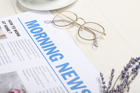 Newspaper and eyeglasses on light wooden background, closeupの写真素材