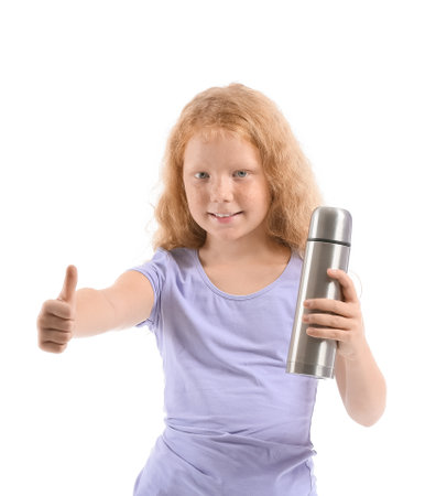Little redhead girl with bottle showing thumb-up on white backgroundの写真素材