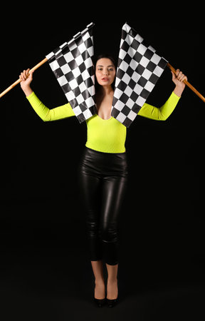 Beautiful young woman with racing flags on dark backgroundの写真素材