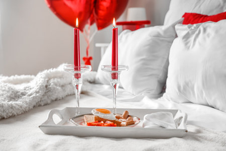 Tray with tasty breakfast and candles in bedroom on Valentine's Day, closeupの写真素材