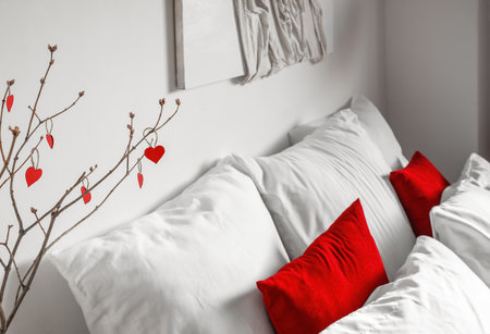 Tree branches with hearts in light bedroom decorated for Valentine's Day