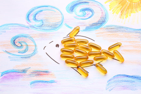 Drawn fish with oil capsules on white backgroundの写真素材