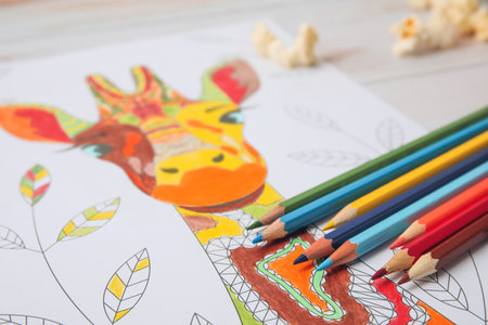 Coloring picture and pencils on wooden background, closeupの写真素材