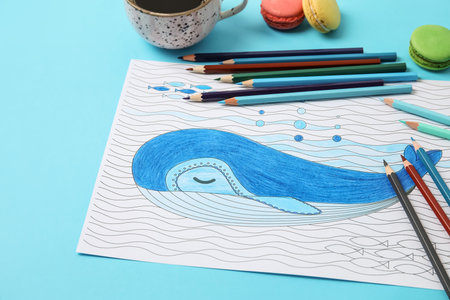 Coloring picture, cup of coffee and pencils on tableの写真素材