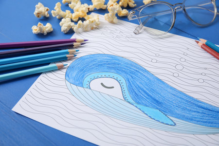 Coloring picture, glasses and pencils on wooden background, closeupの写真素材