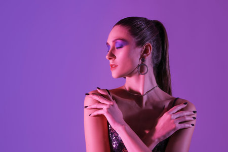 Stylish young woman on dark purple backgroundの写真素材