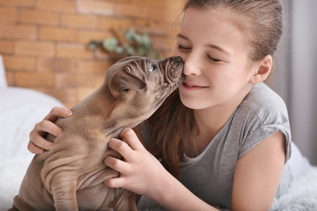 Cute girl with puppy at homeの写真素材