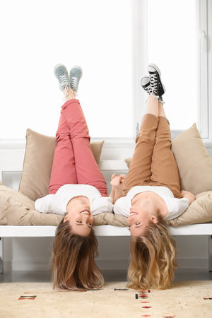 Happy young sisters spending time together at homeの写真素材