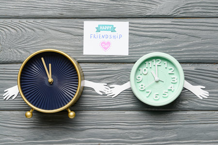 Funny alarm clocks and greeting card for Friendship Day on wooden backgroundの写真素材