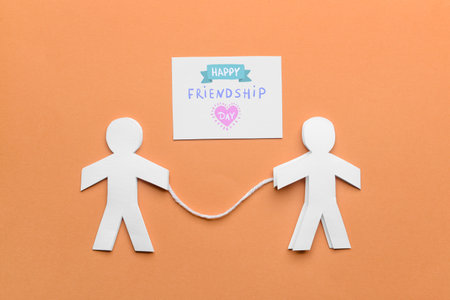 Paper human figures and greeting card for Friendship Day on color backgroundの写真素材