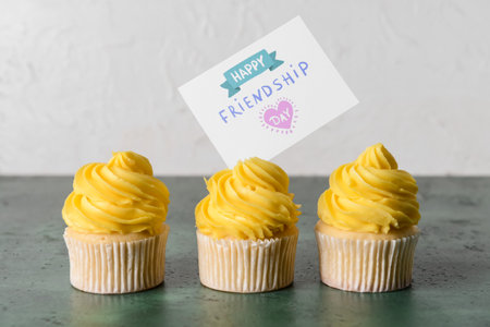 Cupcakes and greeting card for Friendship Day on tableの写真素材
