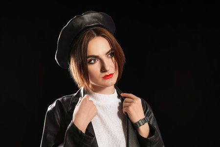Beautiful young woman in stylish hat on dark backgroundの写真素材