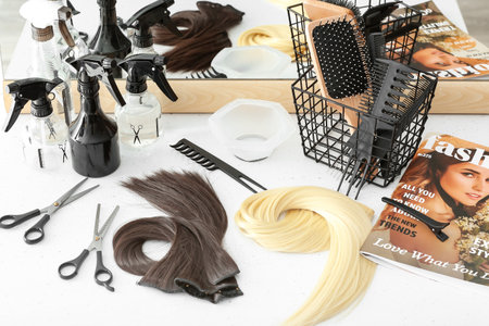 Barber's tools and strands of beautiful hair on table in beauty salonの写真素材