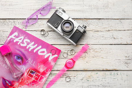 Set of female accessories with photo camera and magazine on light wooden backgroundの写真素材
