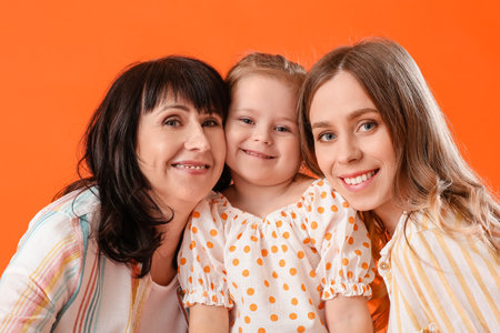 Young woman, her little daughter and mother on color background