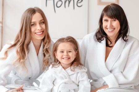 Young woman with her little daughter and mother in the bedroom