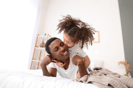 Portrait of happy African-American father and his little daughter at homeの写真素材