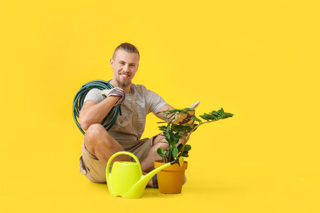 Young male gardener on color backgroundの写真素材