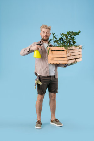 Young male gardener on color backgroundの写真素材