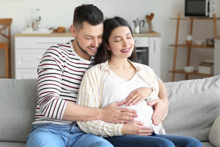 Beautiful pregnant couple at homeの写真素材