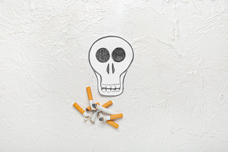 paper skull and cigarettes on light background