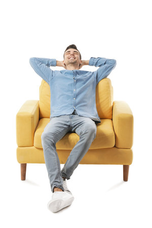 Young man relaxing in armchair on white backgroundの写真素材
