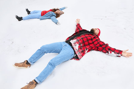 Happy young couple having fun in forest on winter dayの写真素材