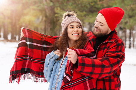 Happy young couple in forest on winter dayの写真素材