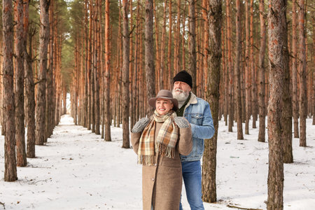 Happy mature couple in forest on winter day