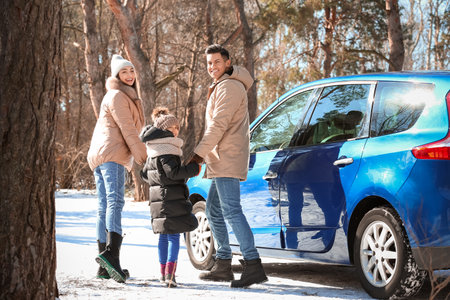 Happy family walking in forest on winter dayの写真素材
