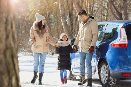 Happy family walking in forest on winter dayの写真素材