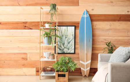 Interior of modern stylish room with sofa, shelf unit and surfboardの写真素材