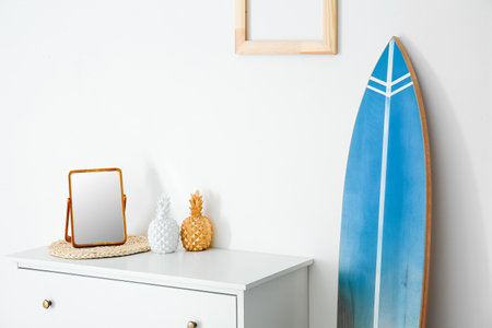 Interior of modern stylish room with chest of drawers and surfboardの写真素材