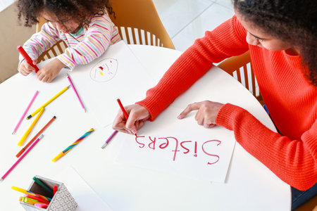 Cute African-American sisters drawing at homeの写真素材