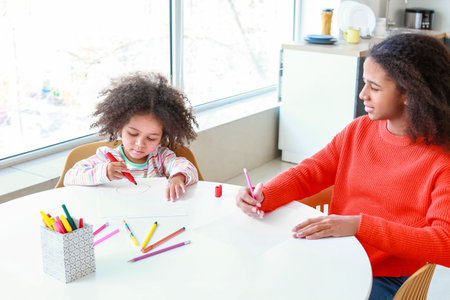 Cute African-American sisters drawing at homeの写真素材